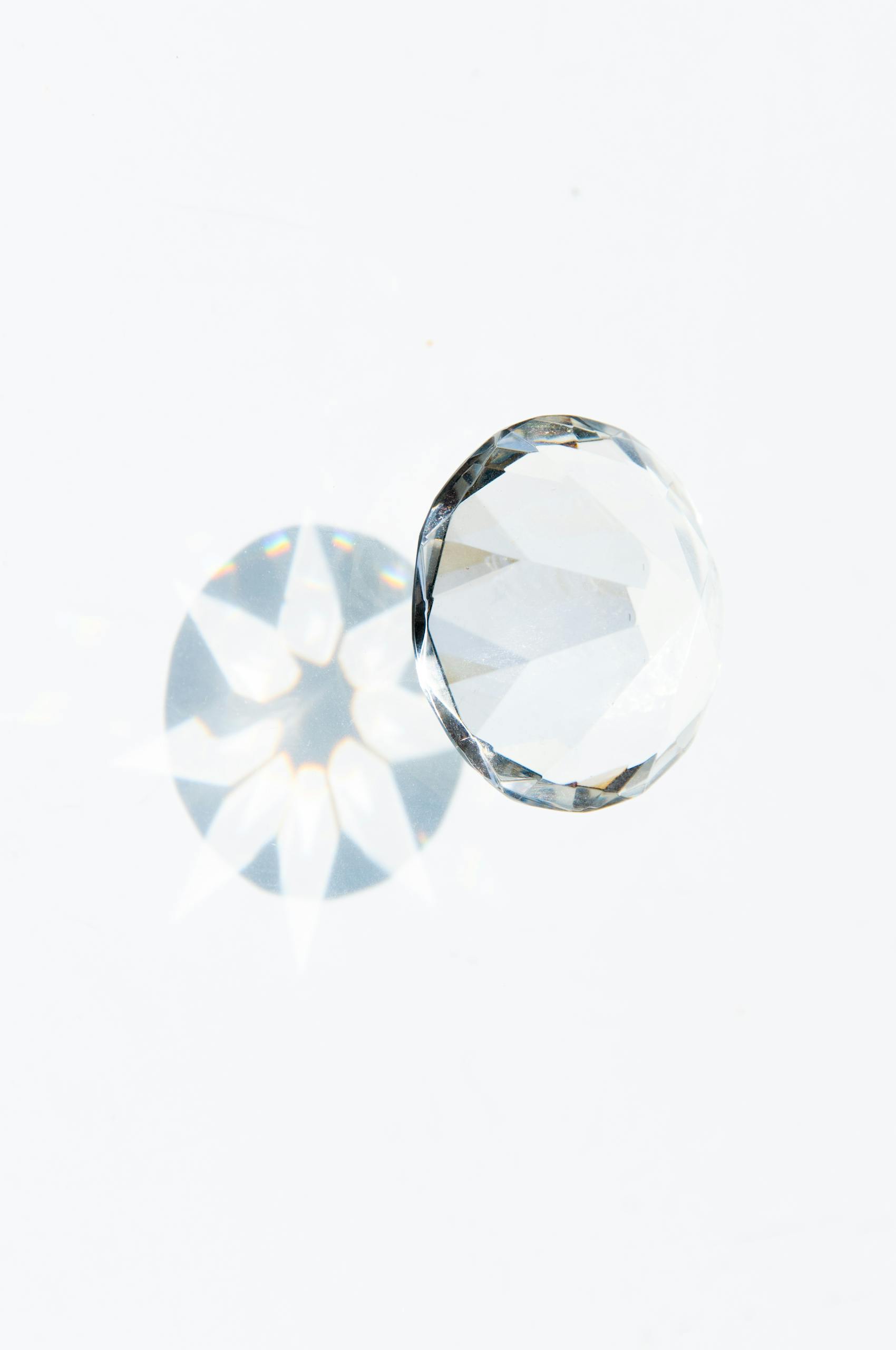 A detailed image of a faceted diamond showcasing a prism effect on a clean white background.