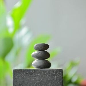 Peaceful zen garden scene with stacked stones and lush greenery background in Bali, Indonesia.